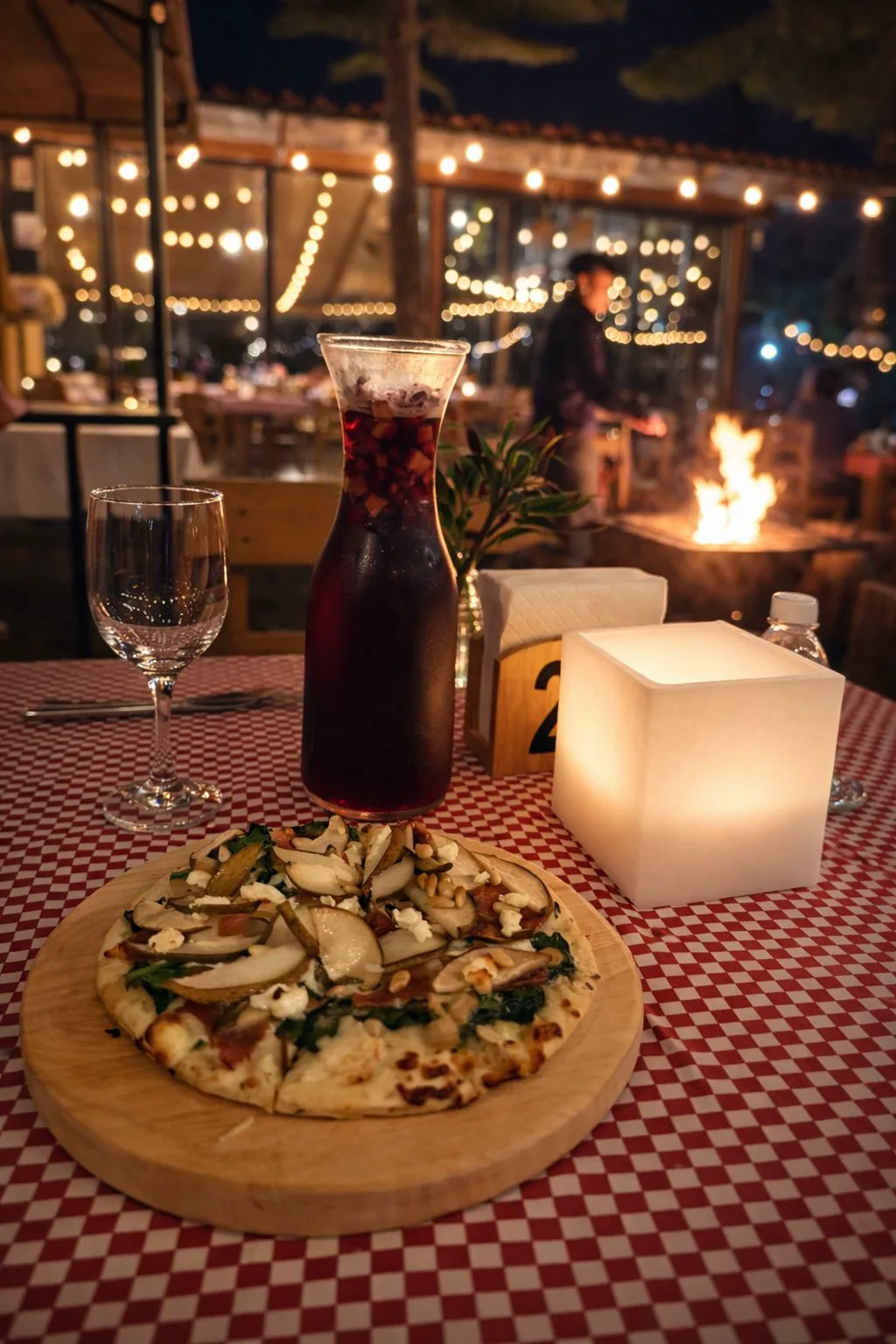 Clericot y pizza en mesa con fogata en Trattoria del Bosque