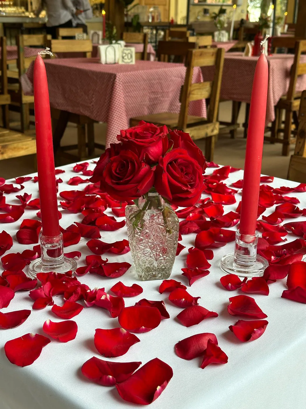Mesa romántica con rosas y velas en Trattoria del Bosque